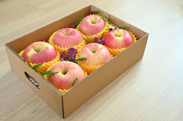 beautiful pink apple in the box on wood floor, healthy fruit