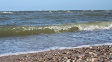 Mavi gökyüzü ve güzel doğal arkaplan ile deniz ve kum üzerinde yavaş çekim su dalgası