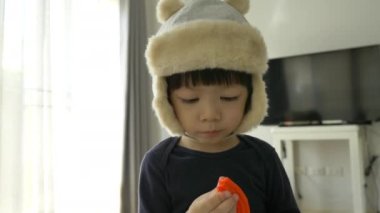 Küçük çocuk plastik hamuru ve inşaat setini oynayan şapka takıyor, yavaş çekim sahnesi.