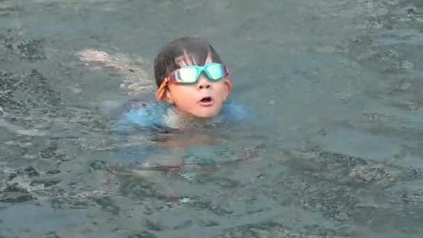 一个享受暑假的男孩 一个快乐的孩子漂浮在游泳池上 一个慢镜头 — 图库视频影像