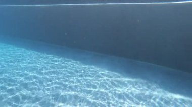 Yüzme havuzunda gün ışığıyla şeffaf mavi suyun yüzeyi, 4K hareket sahnesi