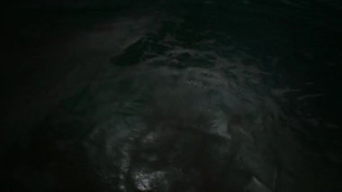 Karanlık zemin üzerinde elektrik ışığıyla su yüzeyinin 4K hareket sahnesi