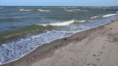 Mavi gökyüzü ve güzel doğal arkaplan ile deniz ve kum üzerinde yavaş çekim su dalgası