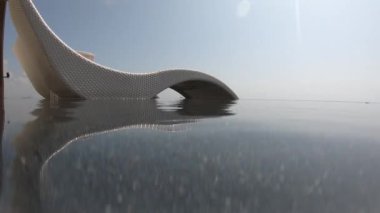 Mavi gökyüzü olan yüzme havuzunda dinlenme yatağı, tropik tatil beldesi 4K hareket sahnesinde terasta su yüzeyi.