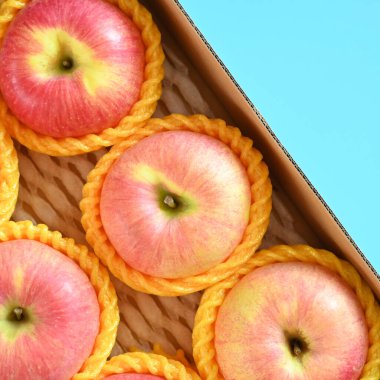 beautiful pink apple in the box on blue background