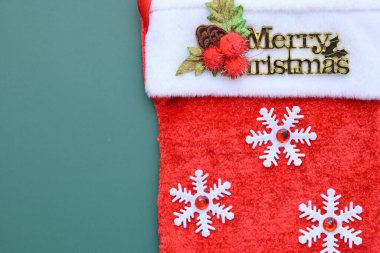Yeşil arka planda kırmızı yün kış çorabı, Noel süslemesi.