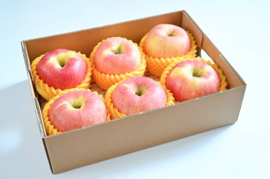 beautiful pink apple in the box on blue background