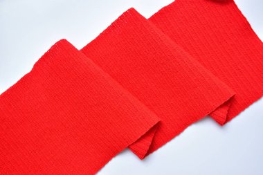 Kırmızı yün örgü kumaş dalgalı, beyaz arkaplanda yünlü kumaş