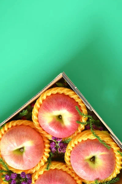 beautiful pink apple in the box on green background