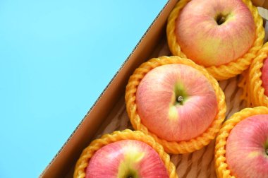 beautiful pink apple in the box on blue background