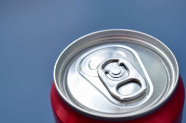 Alüminyum kırmızı bidonlar mavi desen arka planına konur.