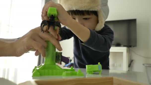 小男孩戴着帽子玩塑料面团和构图 慢镜头 — 图库视频影像
