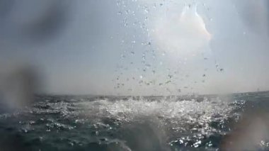 Açık havuzun su dalgası yüzeyi ve mavi gökyüzünde beyaz bulut ile su damlası