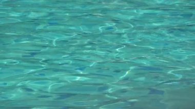 Su dalgası mavi yüzme havuzunda yavaş çekim, güzel havuz dokusu arka planda