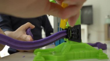 Küçük çocuk plastik hamuru ve inşaat setini oynayan şapka takıyor, yavaş çekim sahnesi.