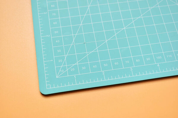 green cutting mat on orange background, object tool for design 