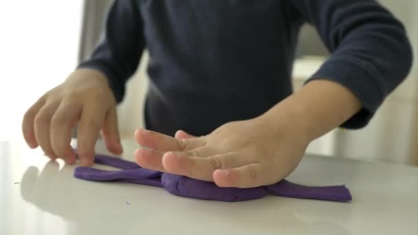紧紧地握住小男孩的手 在家里玩塑料面团 慢镜头 — 图库视频影像