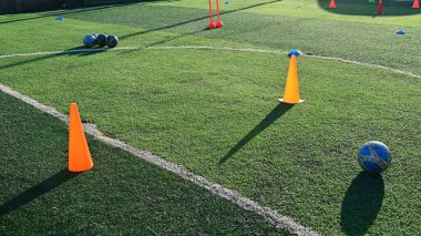 Eğitim konisi ve topu olan yapay yeşil çimen futbol sahası