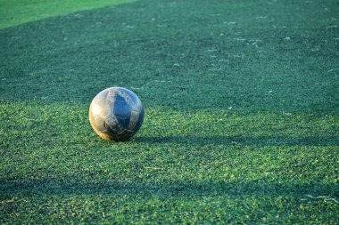 Yapay yeşil çimen futbol sahası ve mavi eğitim topu