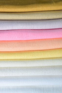 Renkli pamuklu giysiler yığını, beyaz arka planda giysi yığını