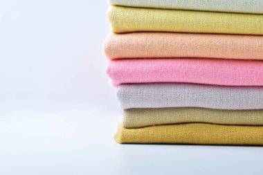 Renkli pamuklu giysiler yığını, beyaz arka planda giysi yığını