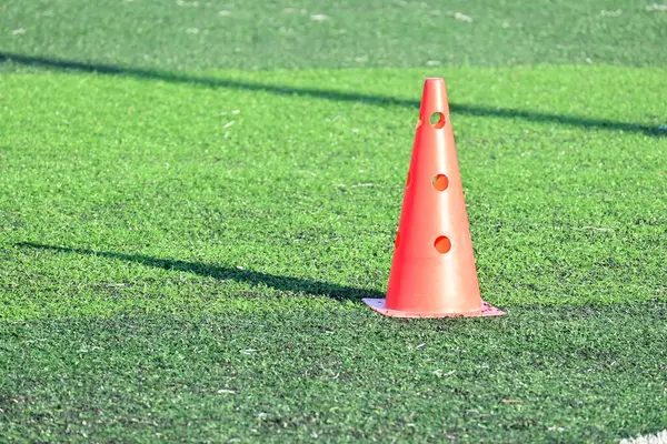 Yapay yeşil çimen futbol sahası ve turuncu eğitim konileri