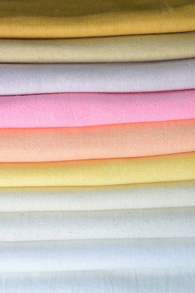 Renkli pamuklu giysiler yığını, beyaz arka planda giysi yığını