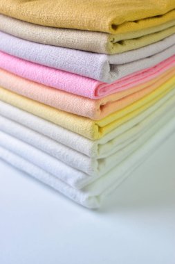 Renkli pamuklu giysiler yığını, beyaz arka planda giysi yığını