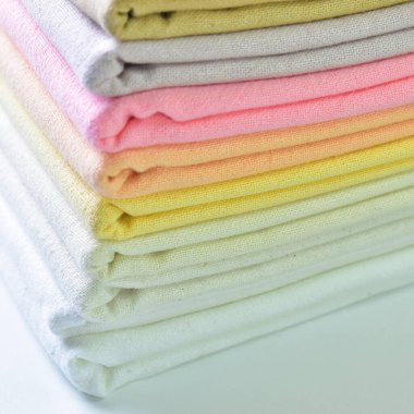 Renkli pamuklu giysiler yığını, beyaz arka planda giysi yığını