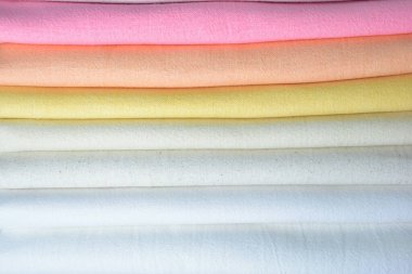 Renkli pamuklu giysiler yığını, beyaz arka planda giysi yığını