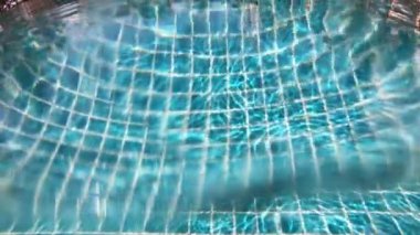 Yüzme havuzunun sualtı görüntüsü, Güneş ışınları yavaş çekim sahnesinden geçiyor