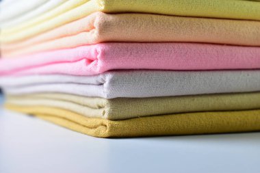 Renkli pamuklu giysiler yığını, beyaz arka planda giysi yığını