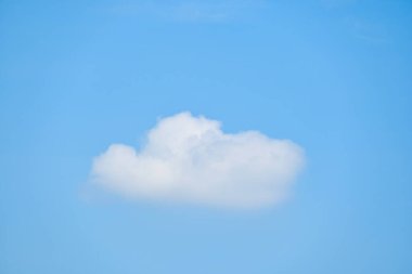 Güzel mavi gökyüzü ve beyaz tüylü tek bulut. Sabah güneş doğuyor, doğal arkaplan.