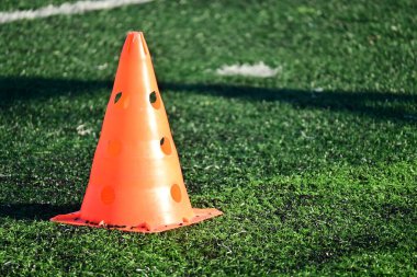 Yapay yeşil çimen futbol sahası ve turuncu eğitim konileri