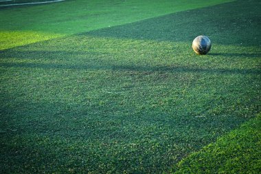 Yapay yeşil çimen futbol sahası ve mavi eğitim topu