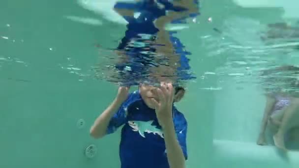 Yüzme Havuzuna Atlayan Tatlı Çocuk Güneş Işığıyla Birlikte Suyun Yüzeyinde — Stok video