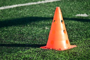 Yapay yeşil çimen futbol sahası ve turuncu eğitim konileri