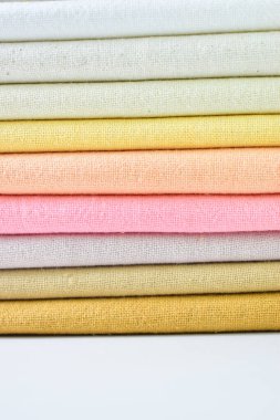 Renkli pamuklu giysiler yığını, beyaz arka planda giysi yığını