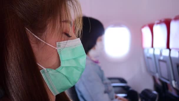 美しい女性の摩耗マスクは飛行機のキャビンで寝ています — ストック動画