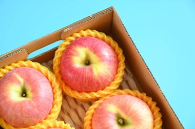 beautiful pink apple in the box on blue background