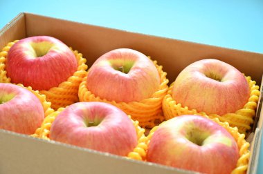 beautiful pink apple in the box on blue background