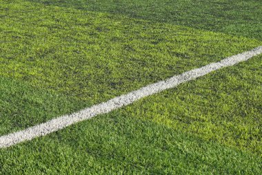 Yapay yeşil çimen çimenlik futbol sahası. Siyah plastik tanecikli.