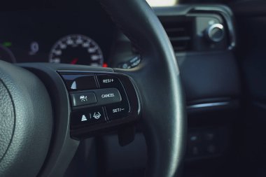 Siyah derili arabanın iç manzarası, düğmeli direksiyon.