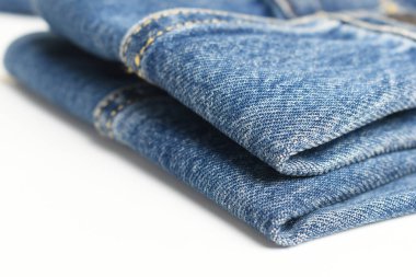 Beyaz arka planda izole edilmiş mavi kot kumaşı, kot tarzı.