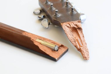 Kırık ahşap akustik gitarın beyaz arka planda izole edilmiş parçası