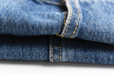 Beyaz arka planda izole edilmiş mavi kot kumaşı, kot tarzı.