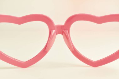 Pastel renk arka planda gözlük pembe kalp şekli