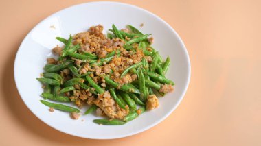 Beyaz tabakta kızarmış yeşil fasulye, Tayland yemeği ve Çin yemeği.