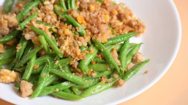 Beyaz tabakta kızarmış yeşil fasulye, Tayland yemeği ve Çin yemeği.