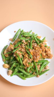 Beyaz tabakta kızarmış yeşil fasulye, Tayland yemeği ve Çin yemeği.